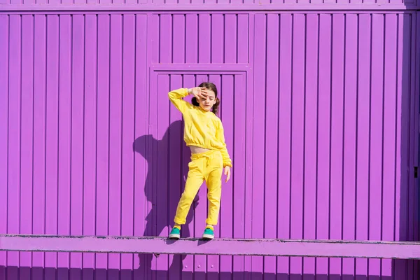 Mała Dziewczynka Ubrana Żółto Stojąca Barze Przed Fioletowymi Drzwiami Garażowymi — Zdjęcie stockowe