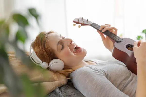 Gondtalan Fiatal Fülhallgatóval Ukulele Otthon — Stock Fotó