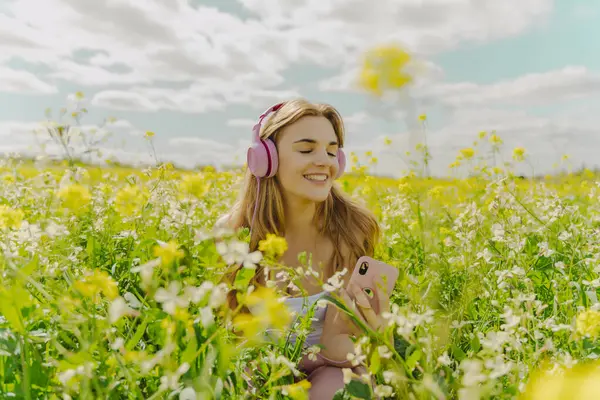 Happy Young Woman Headphones Smartphone Flower Meadow Spring — Zdjęcie stockowe