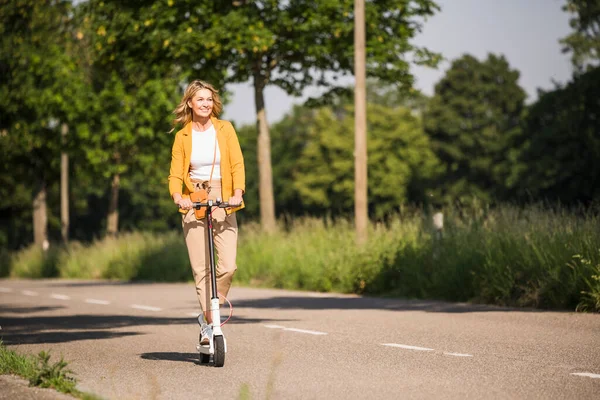 Femme Mûre Chevauchant Scooter Électrique Sur Route Pendant Journée Ensoleillée — Photo