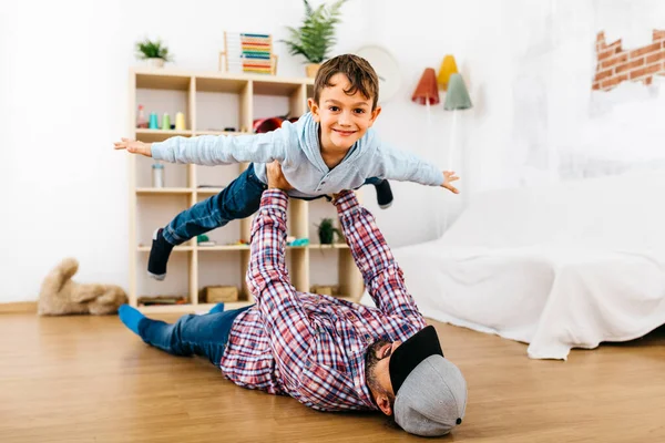 Padre Tendido Suelo Sosteniendo Hijo Alto Fingiendo Volar —  Fotos de Stock