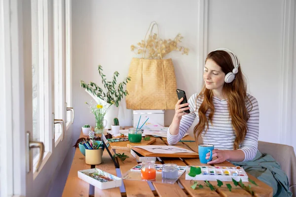 Young Woman Listening Music Smart Phone While Painting Table Home — Stock Photo, Image