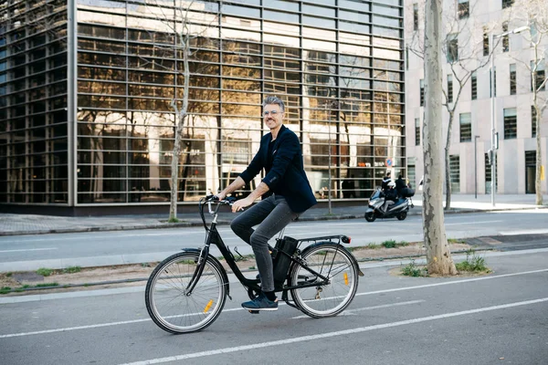 Gråhårig Affärsman Rider Elektrisk Cykel Genom Centrum — Stockfoto