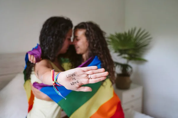 Jovem Mulher Mostrando Texto Mão Enquanto Abraça Namorada Casa — Fotografia de Stock