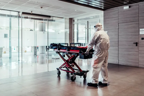 Ambulance Doctor Wearing Protective Suit Pushing Empty Stretcher — Stock Photo, Image