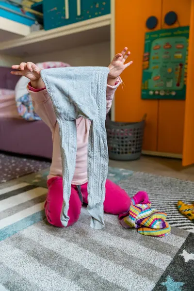 Förskola Flicka Hålla Leggings Medan Knäböja Matta Sovrum Hemma — Stockfoto