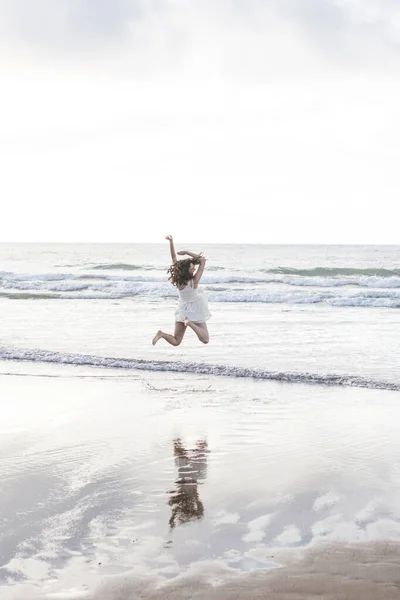 Carefree Young Woman Arms Raised Jumping Shore Sky — Stock Photo, Image