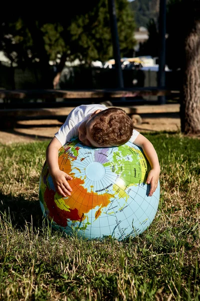 Мальчик Обнимает Земной Шар Травянистой Земле Парке Солнечный День — стоковое фото