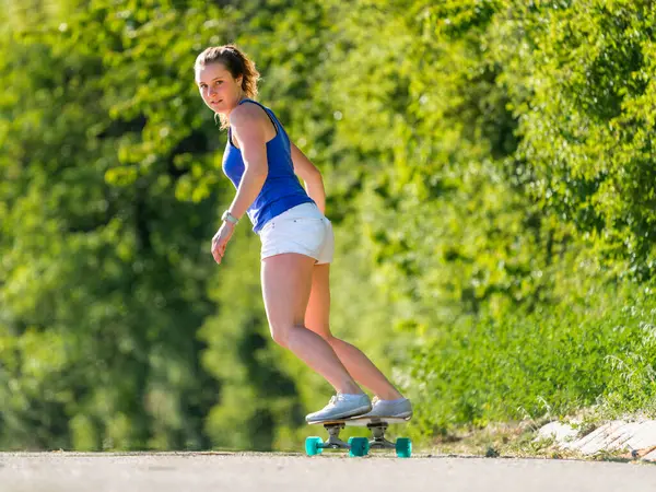 Junge Frau Skateboardet Bei Sonnigem Wetter Auf Straße Bei Pflanzen — Stockfoto