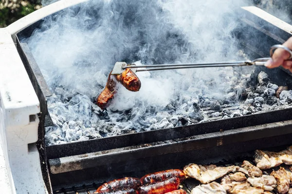 Mano Hombre Joven Sosteniendo Carne Con Pinzas Servir Sobre Parrilla — Foto de Stock