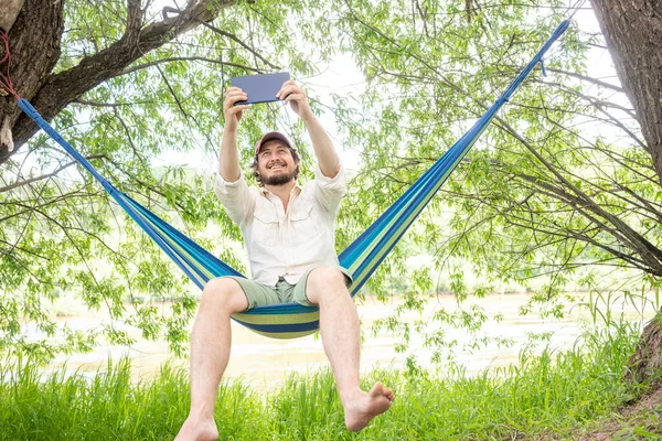 Man Met Behulp Van Tablet Zitten Hangmat — Stockfoto