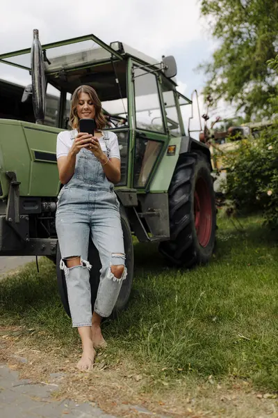 Jonge Vrouw Met Mobiele Telefoon Een Tractor Het Platteland — Stockfoto