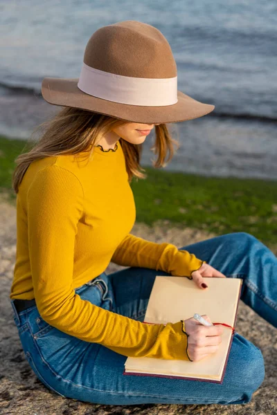 Mujer Joven Con Sombrero Sol Escribiendo Diario Mientras Está Sentado — Foto de Stock