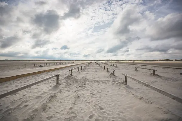 Wolken Über Hölzernen Geländern Die Sich Entlang Des Riesigen Sandstrandes — Stockfoto