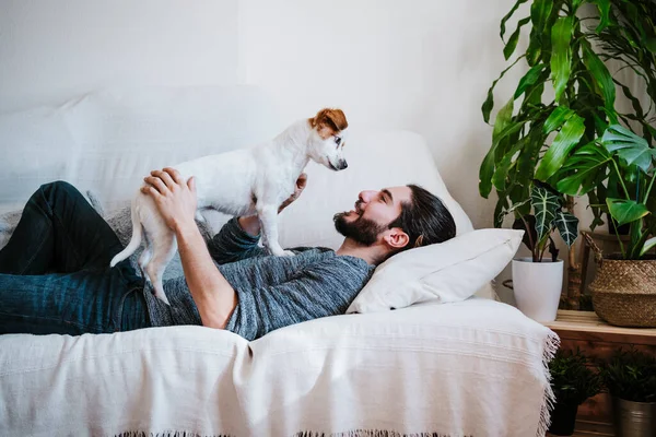 Smiling Man Playing Dog While Lying Sofa Home — Stock Photo, Image