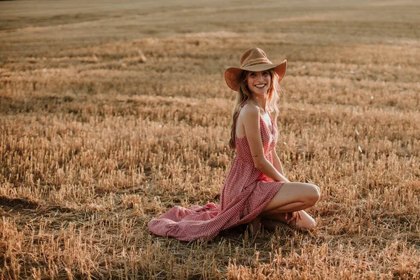 Smiling Young Woman Kneeling Wheat Field Sunset — Zdjęcie stockowe