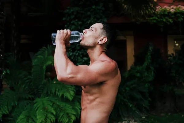 Shirtless Male Athlete Drinking Water While Standing Plants Yard — Stock Photo, Image