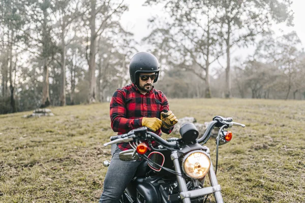 Mężczyzna Rowerzysta Noszenie Rękawiczki Podczas Siedzi Motocyklu Lesie — Zdjęcie stockowe