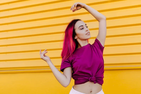 Young Woman Dyed Hair Looking Away While Dancing Yellow Wall — Zdjęcie stockowe