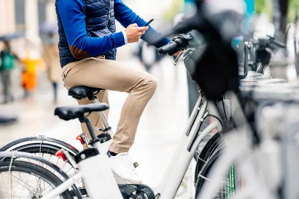 Mężczyzna Korzystający Smartfona Siedzącego Rowerze Elektrycznym Parkingu Podczas Koronawirusu — Zdjęcie stockowe