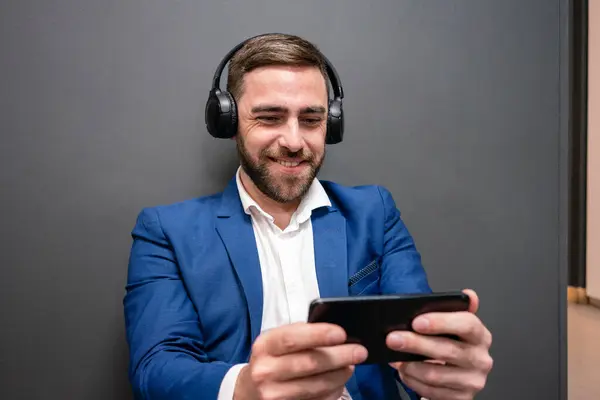 Smiling Businessman Playing Video Game Smart Phone While Sitting Corridor — Stock Photo, Image