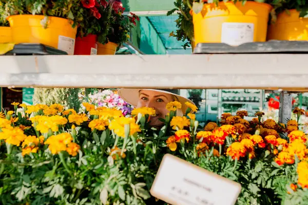 Gülümseyen Yetişkin Bir Kadın Serada Çiçeklere Bakıyor — Stok fotoğraf