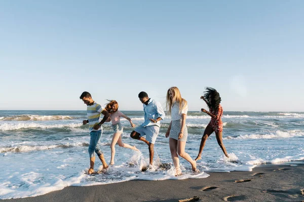 Jóvenes Amigos Jugando Agua Playa Durante Día Soleado —  Fotos de Stock