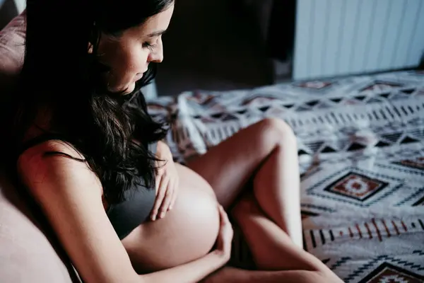 Mujer Embarazada Tocando Estómago Mientras Está Sentada Cama Casa —  Fotos de Stock