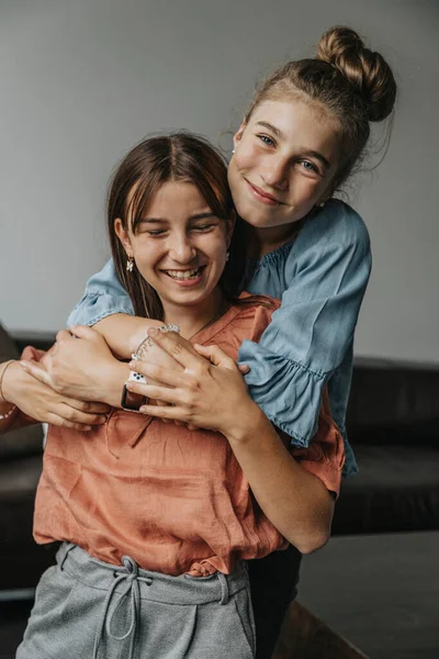 Lächelndes Mädchen Umarmt Freundin Während Sie Hause Steht — Stockfoto