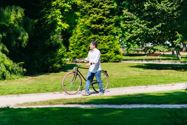 Homem Maduro Olhando Embora Enquanto Caminhava Com Bicicleta Parque Público — Fotografia de Stock