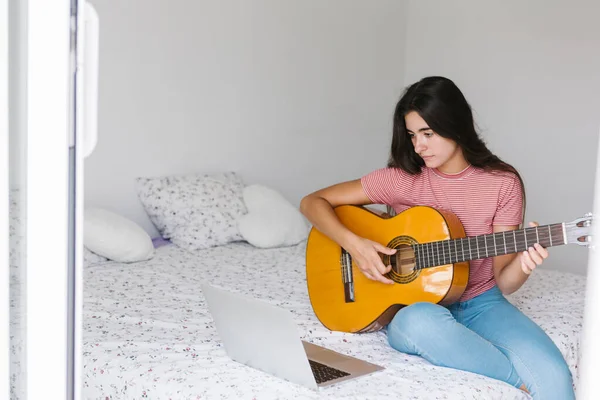 Mujer Joven Aprendiendo Guitarra Línea Mientras Está Sentado Casa Dormitorio — Foto de Stock