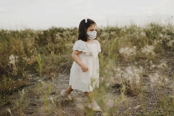 Χαριτωμένο Κορίτσι Φορώντας Προστατευτική Μάσκα Προσώπου Πόδια Στο Πεδίο — Φωτογραφία Αρχείου
