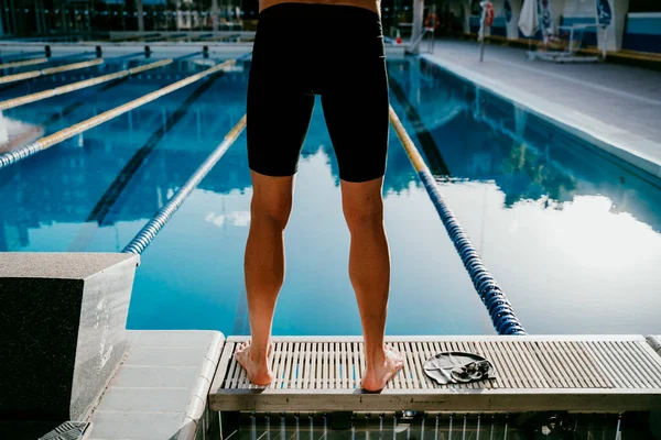 年轻的男子游泳运动员站在船尾 — 图库照片