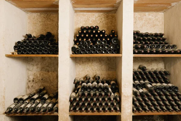 Στοίβα Από Παλιά Μπουκάλια Κρασιού Στο Ράφι Στο Κελάρι — Φωτογραφία Αρχείου