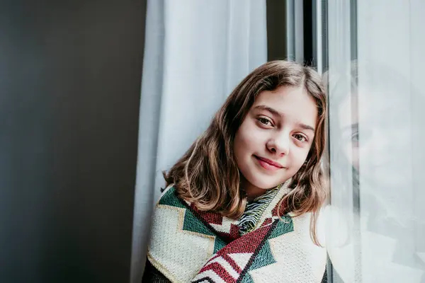 Улыбающаяся Девушка Покрытая Одеялом Сидит Окна Дома — стоковое фото