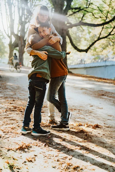 Mother Embracing Sons While Standing Public Park Sunny Day — Stock Photo, Image