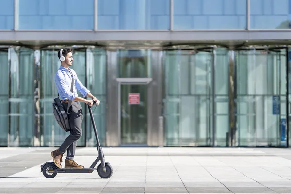 Young Businessman Wearing Headphones Riding Push Scooter Footpath — ストック写真