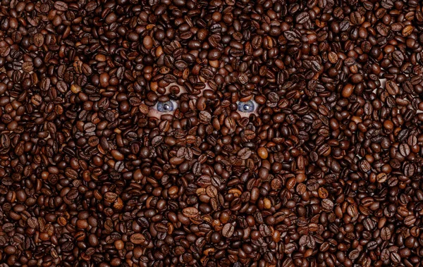 人的眼睛埋在烤咖啡豆里 — 图库照片