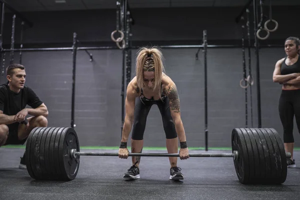 Atletas Assistindo Mulher Pegando Barbell Enquanto Estava Ginásio — Fotografia de Stock