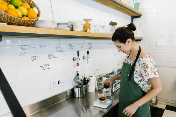 コーヒーショップのキッチンに立ちながら冷たいコーヒーを作るバリスタ — ストック写真