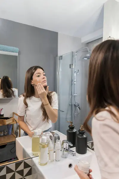 Mulher Aplicando Creme Facial Banheiro Casa — Fotografia de Stock