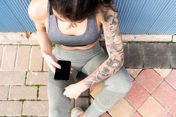 Mid Ενήλικη Γυναίκα Χρησιμοποιώντας Κινητό Τηλέφωνο Ενώ Κάθεται Στο Μονοπάτι — Φωτογραφία Αρχείου