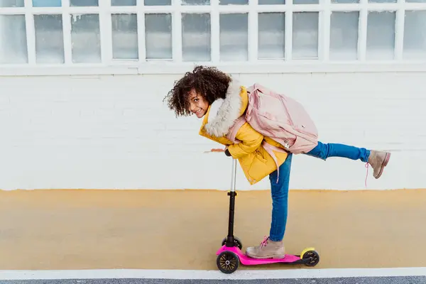 Portræt Munter Pige Med Krøllet Hår Ridning Push Scooter Vej - Stock-foto