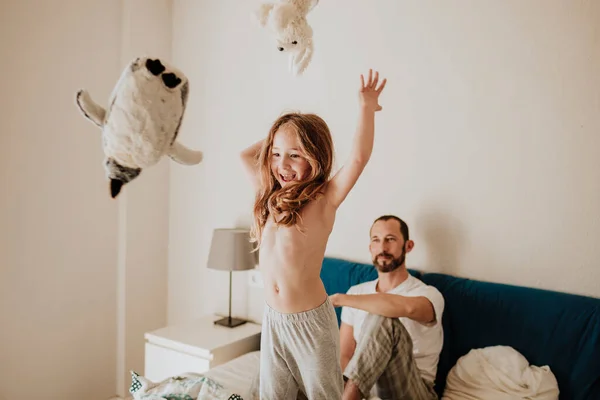 Alegre Chica Lanzando Peluches Mientras Padre Viendo Cama Casa — Foto de Stock