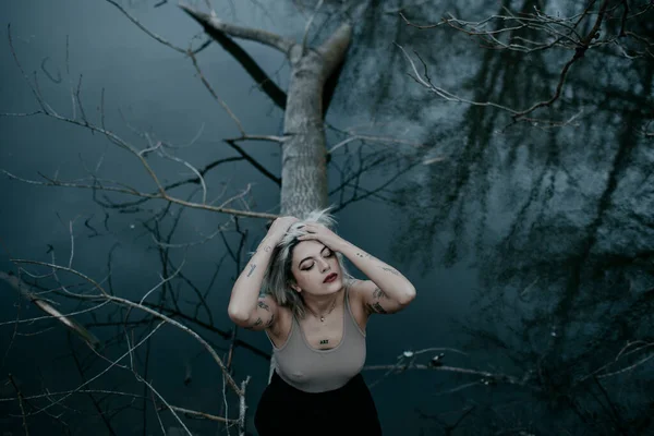 Giovane Donna Con Mano Nei Capelli Seduta Albero Caduto Contro — Foto Stock