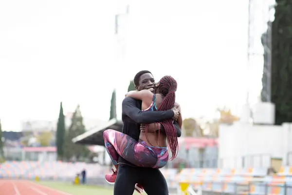 Jovem Desportista Carregando Esportista Abraçando Pista Contra Céu Limpo — Fotografia de Stock