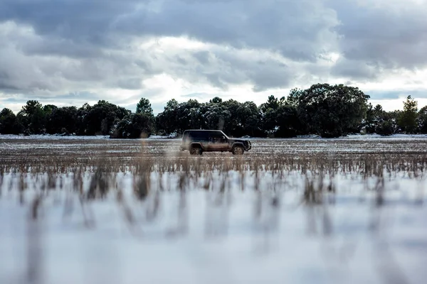 Geländewagen Auf Schneebedecktem Feld Gegen Bewölkten Himmel — Stockfoto