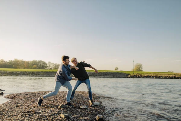 Vader Zoon Gooien Steentjes Rivier Tegen Heldere Lucht Herfst — Stockfoto