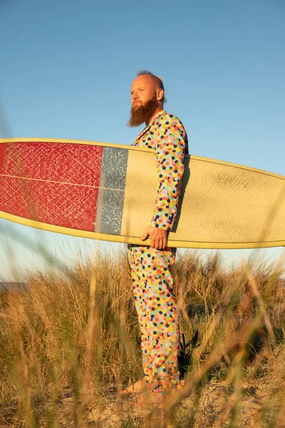 Man Färgglad Kostym Med Surfbräda Tittar Bort Medan Står Mot — Stockfoto