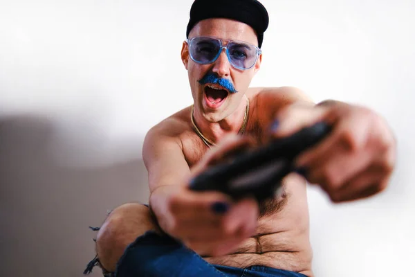 遊び心のある男はサングラスをかけながらゲームコントローラーを持ちます — ストック写真